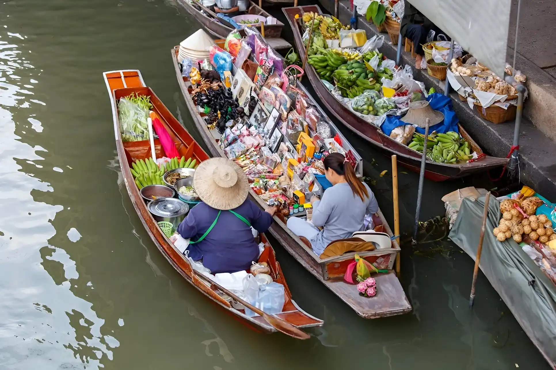 personas montadas en una canoa con comida y otra variedad de artículos para vender, una tradición asiática