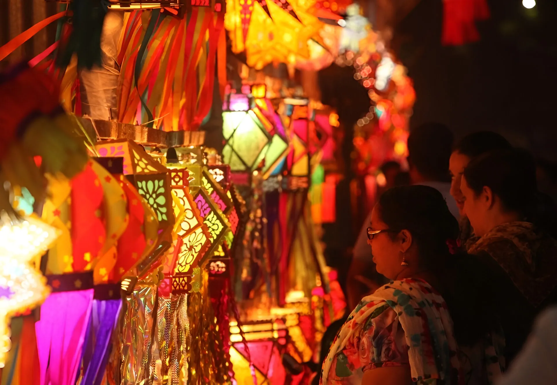 personas recorriendo las coloridas plazas en el festival de las luces en la india.
