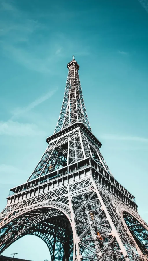 Torre Eiffel en París, Francia, destacándose en un cielo despejado. Icono arquitectónico y atracción principal para los visitantes donde vas a poder descubrir este destino con journale.