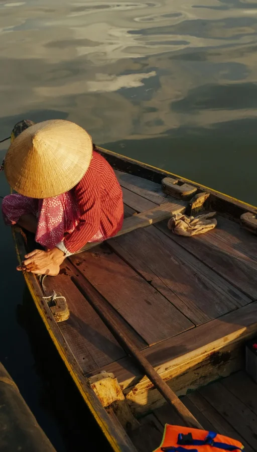 pescador luciendo un sombrero cónico tradicional, donde las canoas y mercados flotantes forman parte del encanto de vietnam.
